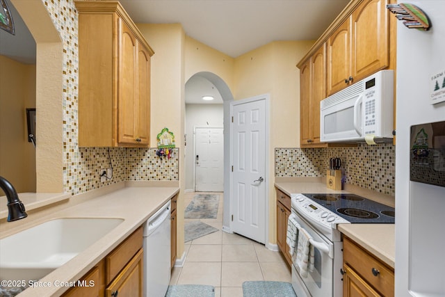 kitchen with sink, white appliances, backsplash, and light tile patterned flooring