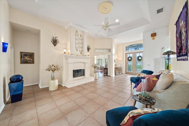 living room featuring ceiling fan, light tile patterned floors, a tray ceiling, and french doors