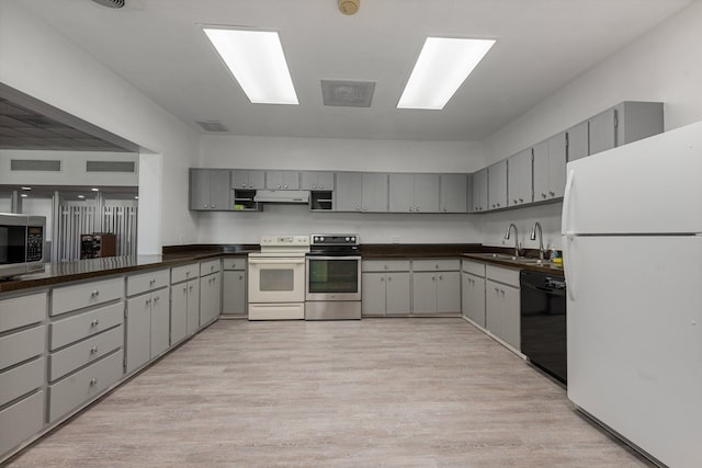 kitchen with gray cabinetry, light wood-type flooring, sink, and appliances with stainless steel finishes