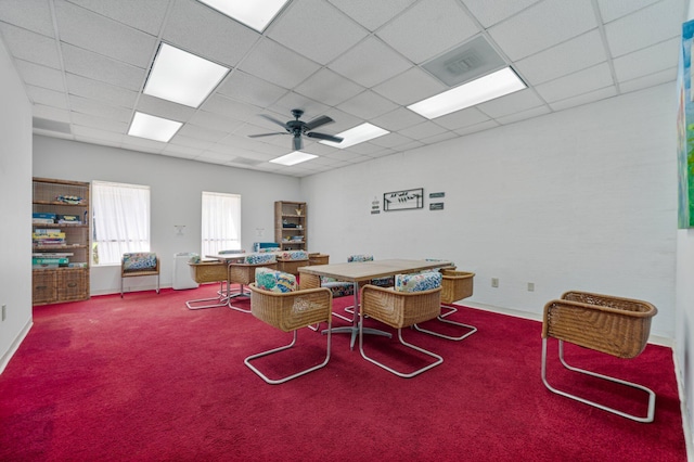 carpeted office with a drop ceiling and ceiling fan