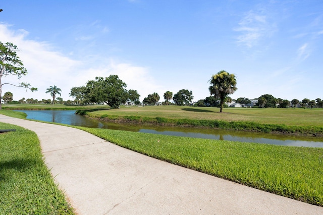 view of community with a yard and a water view