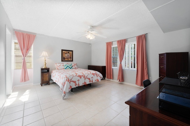 tiled bedroom with a textured ceiling and ceiling fan