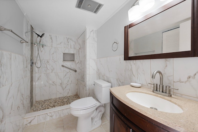 bathroom featuring crown molding, tiled shower, toilet, vanity, and tile walls