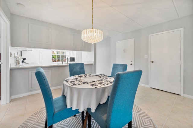 dining room with sink, light tile patterned flooring, and an inviting chandelier