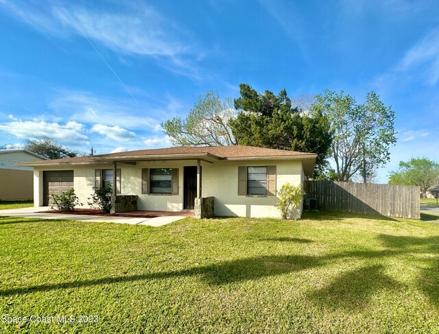 single story home featuring a garage and a front lawn