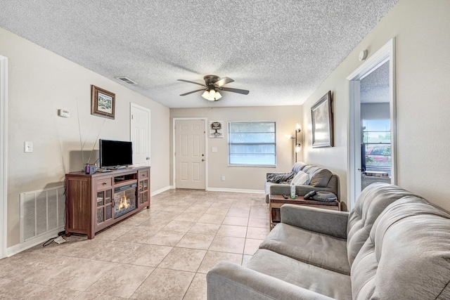 2442 Dianne Dr, Cocoa, FL 32926 - living area featuring a ceiling fan, light tile patterned flooring, a textured ceiling, and baseboards