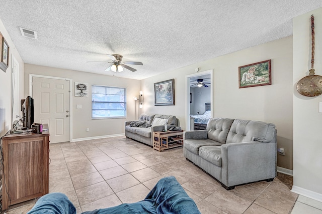 living room featuring light tile patterned floors, a textured ceiling, and ceiling fan