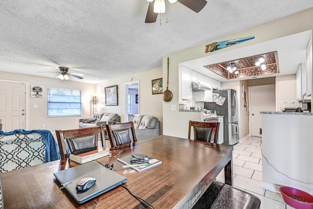 tiled dining area featuring ceiling fan and a textured ceiling