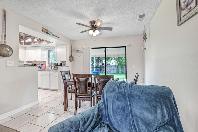 tiled dining area featuring a textured ceiling and ceiling fan