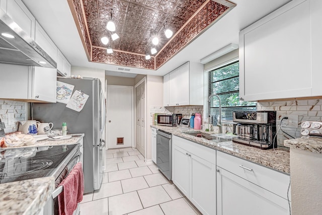 2442 Dianne Dr, Cocoa, FL 32926 - kitchen with appliances with stainless steel finishes, a sink, under cabinet range hood, a tray ceiling, and white cabinets