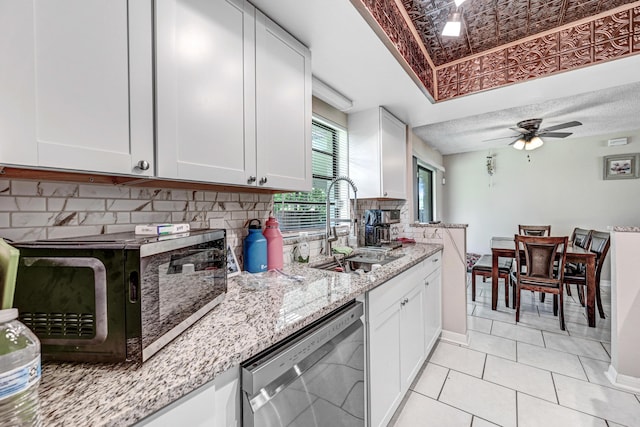 2442 Dianne Dr, Cocoa, FL 32926 - kitchen with black microwave, dishwasher, a sink, tasteful backsplash, and light stone countertops