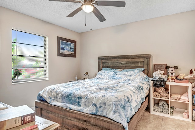 tiled bedroom with a textured ceiling and ceiling fan