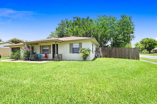 ranch-style home with cooling unit, a garage, and a front yard