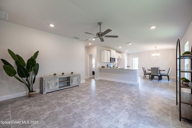 living room featuring ceiling fan with notable chandelier