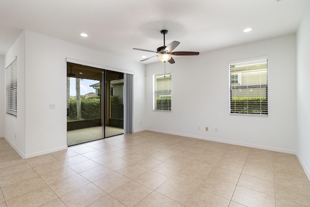 spare room with ceiling fan and light tile patterned floors