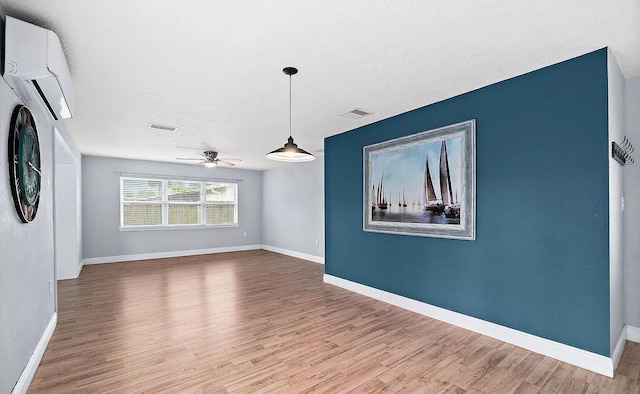 unfurnished living room featuring ceiling fan, hardwood / wood-style floors, and a textured ceiling