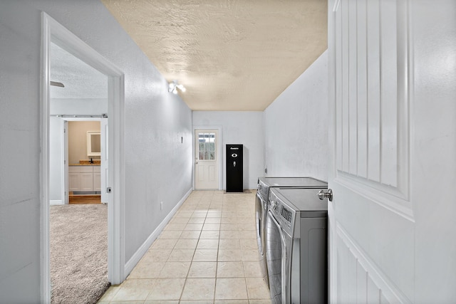 kitchen featuring washer and dryer, light carpet, and a textured ceiling