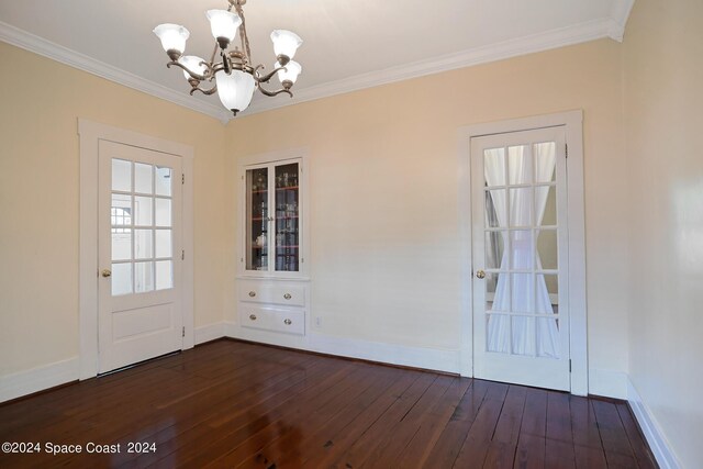 interior space featuring ornamental molding, a chandelier, and dark hardwood / wood-style flooring