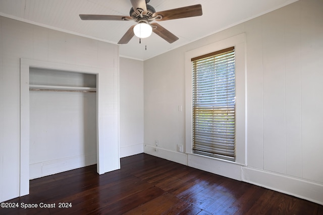 unfurnished bedroom featuring ceiling fan, a closet, crown molding, and dark hardwood / wood-style flooring