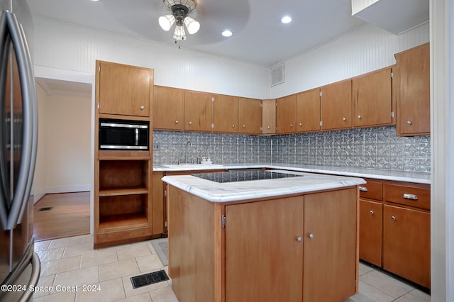 kitchen with ceiling fan, light tile patterned floors, appliances with stainless steel finishes, a center island, and crown molding