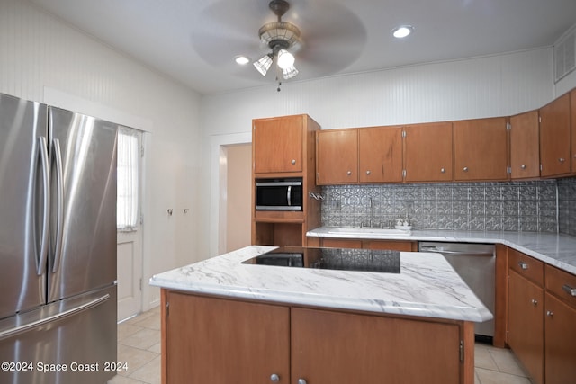 kitchen featuring tasteful backsplash, sink, a kitchen island, appliances with stainless steel finishes, and ceiling fan