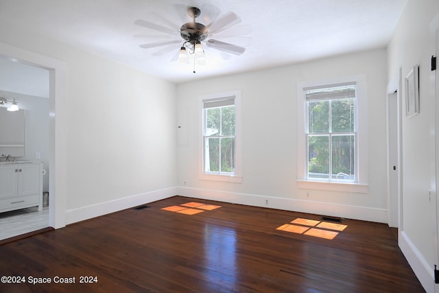 spare room with ceiling fan, sink, and dark hardwood / wood-style flooring