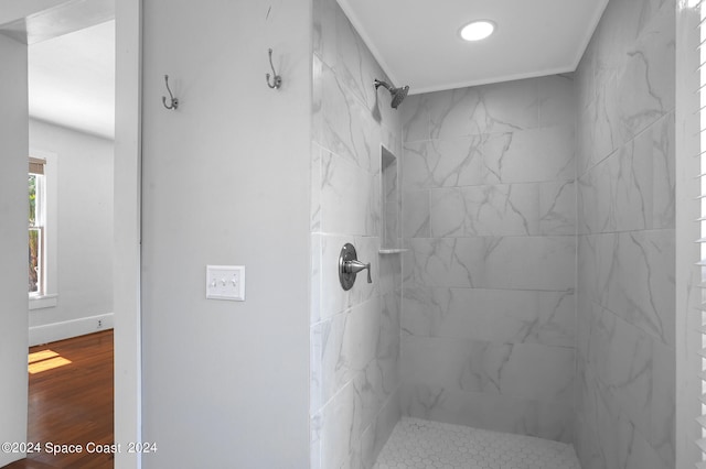 bathroom with wood-type flooring and a tile shower