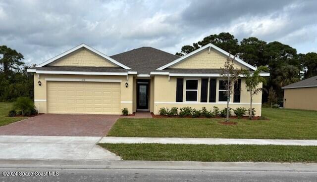 view of front of house featuring a front lawn and a garage