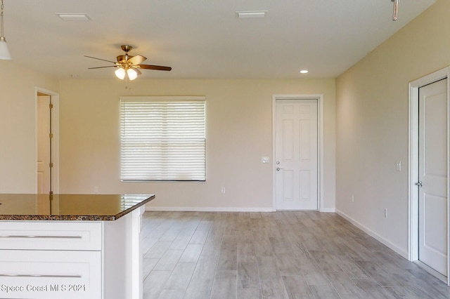 kitchen with light hardwood / wood-style floors, white cabinetry, and ceiling fan