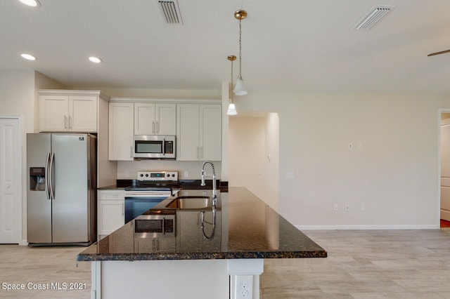 kitchen with light wood-type flooring, white cabinets, stainless steel appliances, pendant lighting, and sink