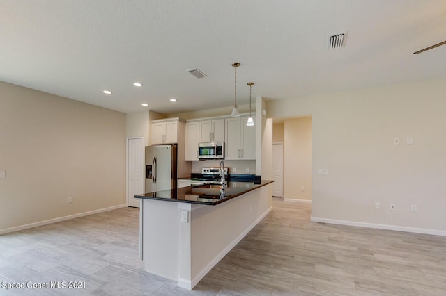 1071 Grapefruit Rd SE, Palm Bay, FL 32909 - kitchen featuring stainless steel appliances, dark countertops, white cabinetry, recessed lighting, and light wood-style flooring