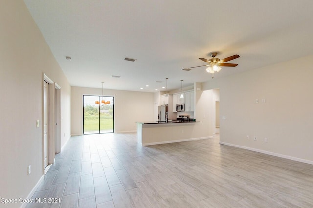 1071 Grapefruit Rd SE, Palm Bay, FL 32909 - unfurnished living room featuring a ceiling fan, light wood-style flooring, and a chandelier