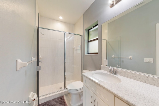 bathroom with vanity, toilet, tile patterned floors, and walk in shower