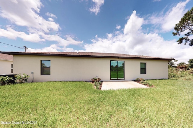 1071 Grapefruit Rd SE, Palm Bay, FL 32909 - back of property with a patio, stucco siding, and a lawn
