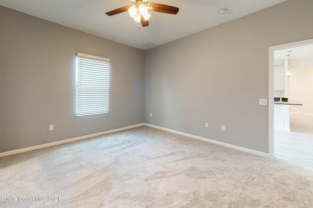 carpeted empty room featuring ceiling fan