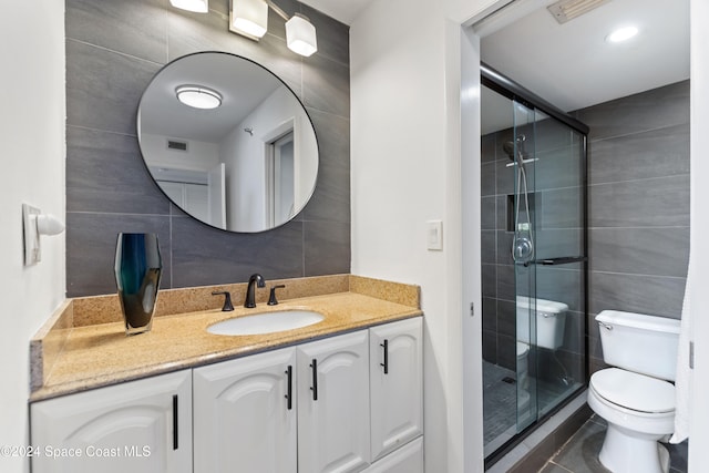 bathroom with vanity, toilet, tile walls, and walk in shower