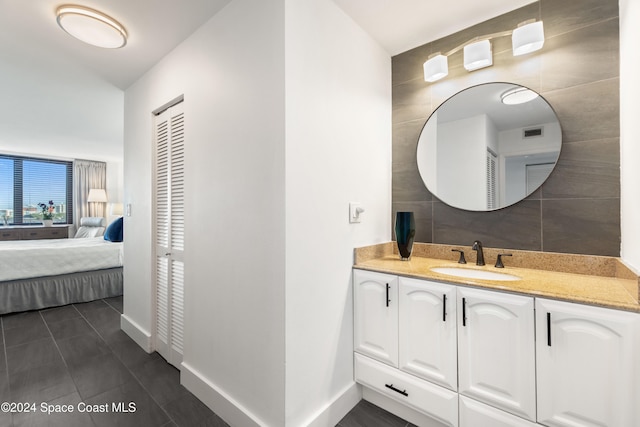 bathroom with tile patterned flooring, vanity, and tile walls