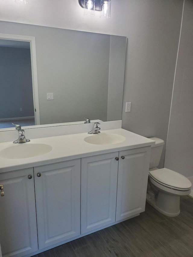 bathroom with hardwood / wood-style flooring, vanity, and toilet