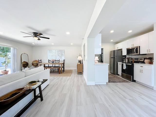 living room featuring ceiling fan and light wood-type flooring