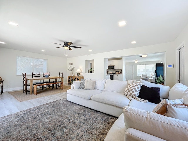 living room featuring hardwood / wood-style floors, ceiling fan, and plenty of natural light