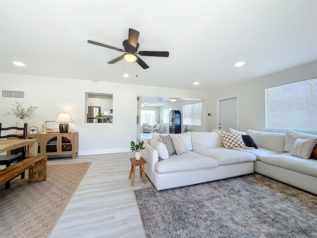 living room with ceiling fan and light hardwood / wood-style flooring