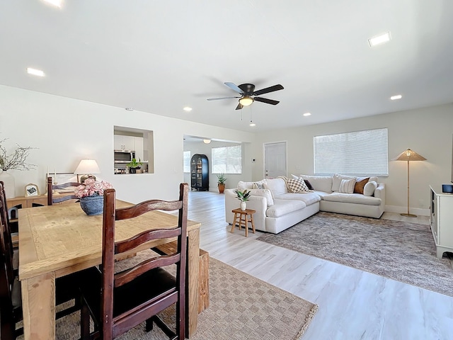 living room with ceiling fan and light hardwood / wood-style flooring