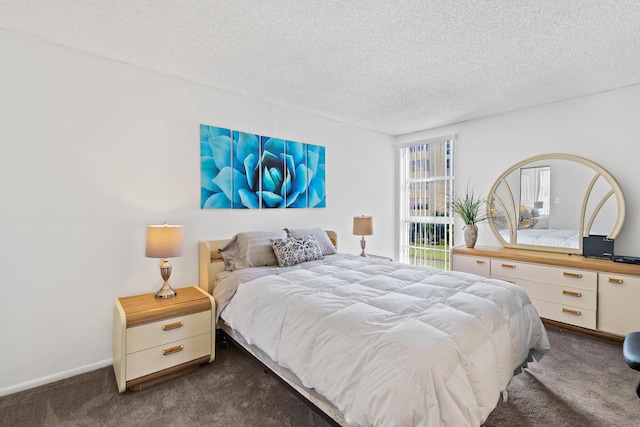 bedroom featuring dark colored carpet and a textured ceiling