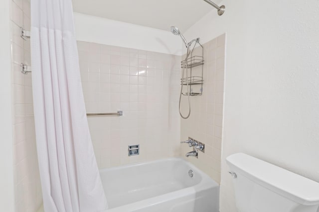 bathroom featuring shower / tub combo and toilet