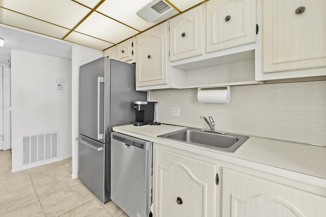 kitchen featuring tasteful backsplash, dishwasher, light tile patterned floors, and sink