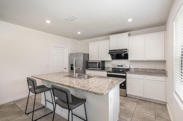 kitchen featuring white cabinetry, sink, a breakfast bar area, a kitchen island with sink, and appliances with stainless steel finishes