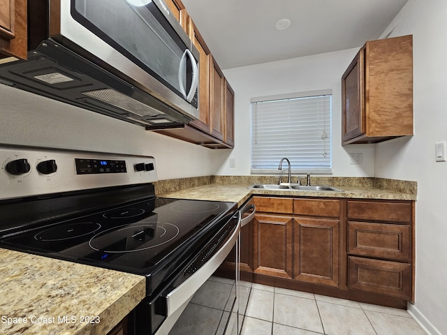 kitchen featuring sink, stainless steel appliances, and light tile patterned flooring