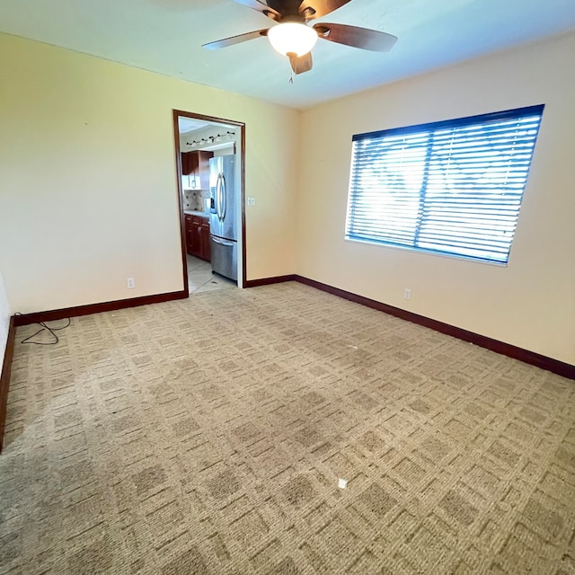 spare room featuring carpet floors and ceiling fan