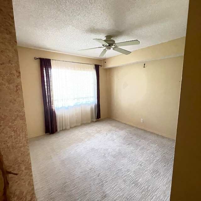 unfurnished room with light carpet, a textured ceiling, and ceiling fan