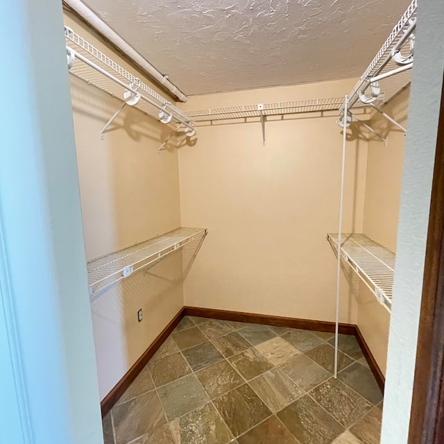 spacious closet with dark tile patterned flooring